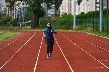 Image showing A muslim woman in a burqa sports muslim clothes running on a marathon course and preparing for upcoming competitions