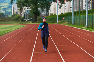 Image showing A muslim woman in a burqa sports muslim clothes running on a marathon course and preparing for upcoming competitions