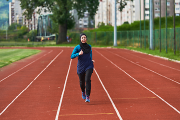 Image showing A muslim woman in a burqa sports muslim clothes running on a marathon course and preparing for upcoming competitions