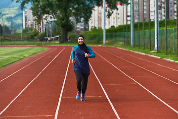 Image showing A muslim woman in a burqa sports muslim clothes running on a marathon course and preparing for upcoming competitions