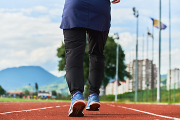 Image showing A muslim woman in a burqa sports muslim clothes running on a marathon course and preparing for upcoming competitions