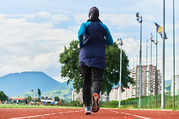 Image showing A muslim woman in a burqa sports muslim clothes running on a marathon course and preparing for upcoming competitions