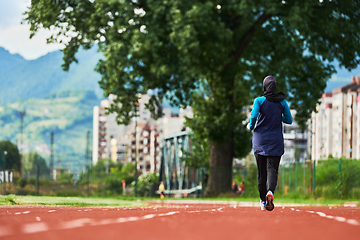 Image showing A muslim woman in a burqa sports muslim clothes running on a marathon course and preparing for upcoming competitions