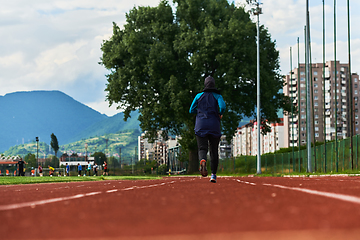 Image showing A muslim woman in a burqa sports muslim clothes running on a marathon course and preparing for upcoming competitions