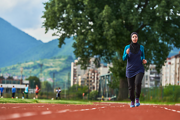 Image showing A muslim woman in a burqa sports muslim clothes running on a marathon course and preparing for upcoming competitions