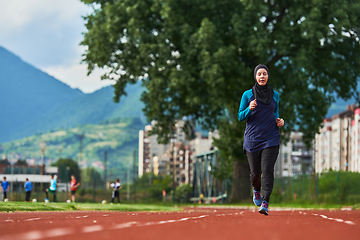 Image showing A muslim woman in a burqa sports muslim clothes running on a marathon course and preparing for upcoming competitions