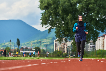 Image showing A muslim woman in a burqa sports muslim clothes running on a marathon course and preparing for upcoming competitions