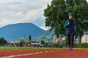 Image showing A muslim woman in a burqa sports muslim clothes running on a marathon course and preparing for upcoming competitions