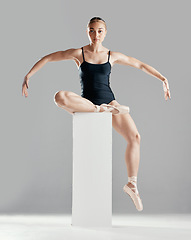 Image showing Balance, ballerina or woman on block in studio in creative portrait or elegant performance for art or freedom. Girl, dancer or ballet dancing or training to exercise on platform or white background