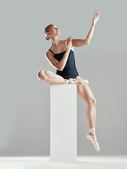 Image showing Performance, ballerina or woman on block in studio in creative routine or elegant act for art or freedom. Girl, dancer or classy ballet dancing or training to exercise on platform or white background