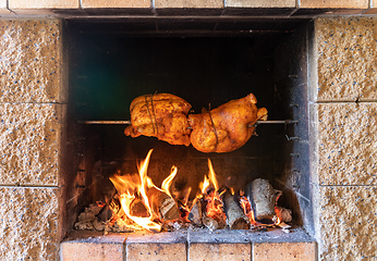 Image showing chicken roasting on a spit