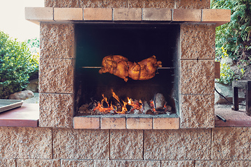 Image showing chicken roasting on a spit