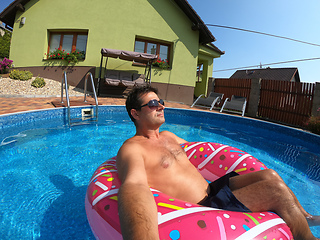 Image showing Happy man relax on inflatable ring. Holiday 2020