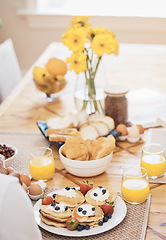 Image showing Pancakes, breakfast and orange juice on table in home in the morning. Bread waffle, hands and fruits for eating, healthy diet and strawberry cream in wellness nutrition, blueberry food and egg meal.