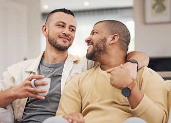 Image showing Happy, love and gay couple relaxing on a sofa with a cup of coffee in the living room together. Smile, bonding and young lgbtq men with a latte sitting in the living room of their modern apartment.