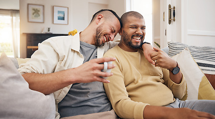 Image showing Laughing, relax and a gay couple on the sofa with coffee, conversation or love in a house. Happy, together and lgbt men on the living room couch for a funny story, communication or speaking with tea