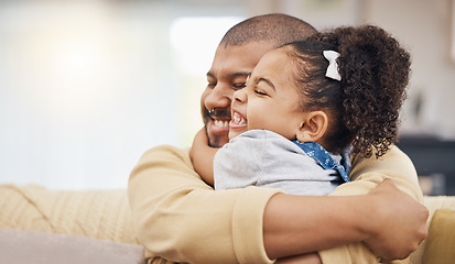 Image showing Smile, love and girl hugging her father while relaxing on a sofa in the living room together. Happy, care and child bonding, embracing and sitting with her young dad in the lounge of their home.