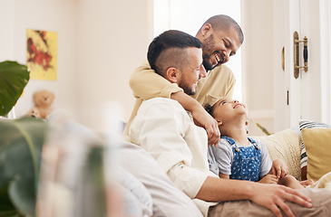 Image showing Gay, happy family and a child hug on a home sofa with love, care and safety in a lounge. Lgbtq men, adoption and parents with a foster girl kid together on a couch for happiness, bonding and to relax