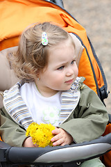 Image showing girl with flower in a pram