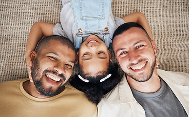 Image showing Gay dad, blended family and foster with a girl lying together on the floor of the home for adoption from above. LGBT love, children or kids and a daughter bonding with her happy parents in the house