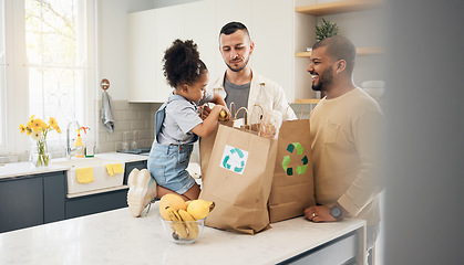 Image showing Recycling, blended family or adoption with a daughter and gay couple in the home kitchen for sustainability. LGBT, eco friendly or waste with a girl and parents unpacking bananas from a grocery bag