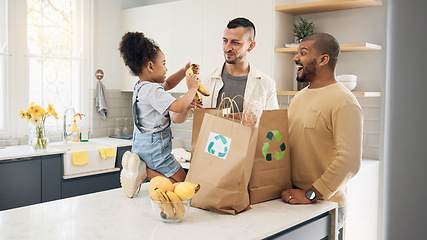 Image showing Recycling, blended family or adoption with a girl and gay couple in the home kitchen for sustainability. LGBT, eco friendly or waste with a daughter and parents unpacking bananas from a grocery bag