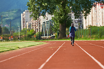 Image showing A muslim woman in a burqa sports muslim clothes running on a marathon course and preparing for upcoming competitions