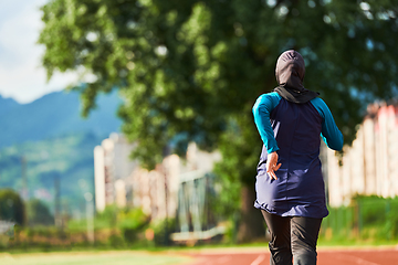 Image showing A muslim woman in a burqa sports muslim clothes running on a marathon course and preparing for upcoming competitions