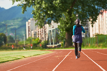 Image showing A muslim woman in a burqa sports muslim clothes running on a marathon course and preparing for upcoming competitions