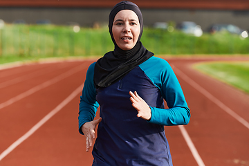 Image showing A muslim woman in a burqa sports muslim clothes running on a marathon course and preparing for upcoming competitions