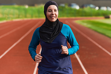 Image showing A muslim woman in a burqa sports muslim clothes running on a marathon course and preparing for upcoming competitions