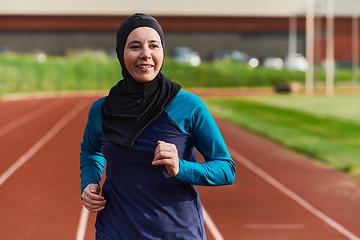 Image showing A muslim woman in a burqa sports muslim clothes running on a marathon course and preparing for upcoming competitions