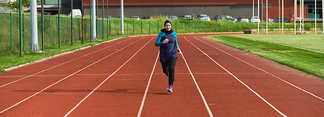 Image showing A muslim woman in a burqa sports muslim clothes running on a marathon course and preparing for upcoming competitions