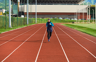 Image showing A muslim woman in a burqa sports muslim clothes running on a marathon course and preparing for upcoming competitions