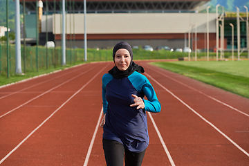 Image showing A muslim woman in a burqa sports muslim clothes running on a marathon course and preparing for upcoming competitions