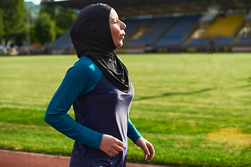 Image showing A muslim woman in a burqa sports muslim clothes running on a marathon course and preparing for upcoming competitions