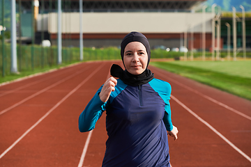 Image showing A muslim woman in a burqa sports muslim clothes running on a marathon course and preparing for upcoming competitions