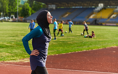 Image showing A Muslim woman with a burqa, an Islamic sportswoman resting after a vigorous training session on the marathon course. A hijab woman is preparing for a marathon competition