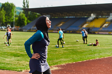 Image showing A Muslim woman with a burqa, an Islamic sportswoman resting after a vigorous training session on the marathon course. A hijab woman is preparing for a marathon competition