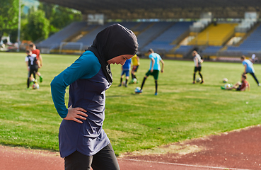 Image showing A Muslim woman with a burqa, an Islamic sportswoman resting after a vigorous training session on the marathon course. A hijab woman is preparing for a marathon competition