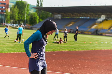 Image showing A Muslim woman with a burqa, an Islamic sportswoman resting after a vigorous training session on the marathon course. A hijab woman is preparing for a marathon competition