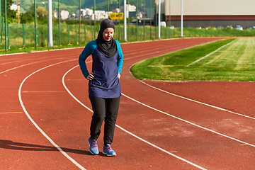 Image showing A Muslim woman with a burqa, an Islamic sportswoman resting after a vigorous training session on the marathon course. A hijab woman is preparing for a marathon competition