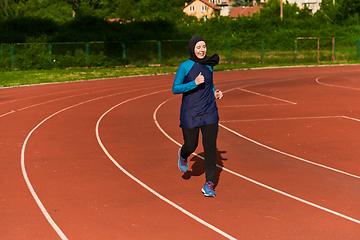 Image showing A muslim woman in a burqa sports muslim clothes running on a marathon course and preparing for upcoming competitions