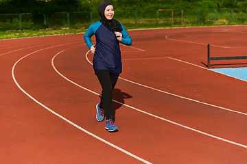 Image showing A muslim woman in a burqa sports muslim clothes running on a marathon course and preparing for upcoming competitions