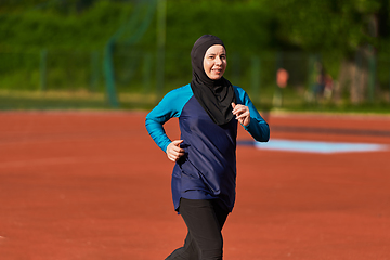 Image showing A muslim woman in a burqa sports muslim clothes running on a marathon course and preparing for upcoming competitions