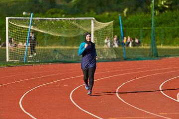 Image showing A muslim woman in a burqa sports muslim clothes running on a marathon course and preparing for upcoming competitions