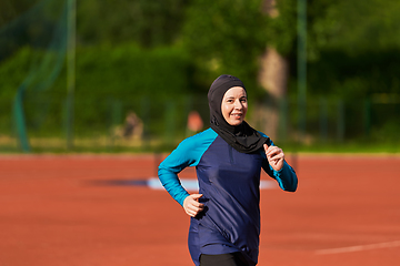 Image showing A muslim woman in a burqa sports muslim clothes running on a marathon course and preparing for upcoming competitions