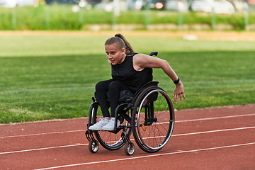 Image showing A woman with disablity driving a wheelchair on a track while preparing for the Paralympic Games