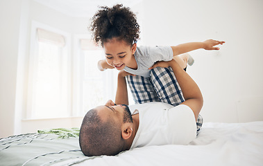 Image showing Dad, child and bed with airplane game, happy bonding and fun morning playing for father and daughter in home. Family, love and playful energy, man holding girl in air and laughing in bedroom together