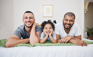 Image showing Gay, happy family and a child on a bed at home with love, care and safety in a bedroom. Lgbtq men, adoption and interracial parents with foster girl kid together in morning with a smile and happiness